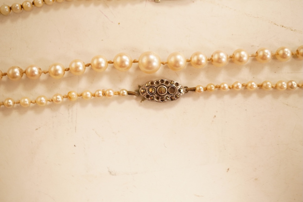 Two single strands graduated cultured pearl necklaces, both with marcasite set sterling clasps, longest, 64cm.